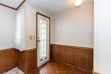 Foyer with wooden walls, a wainscoted wall, and a 