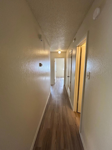 Corridor featuring wood finished floors, baseboar