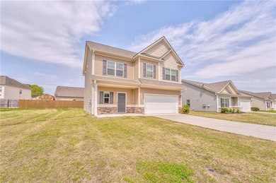Craftsman house with driveway, stone siding, an at
