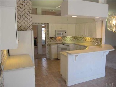 View of kitchen from the breakfast area with lighted ceiling fan, Kenmore appliances & bar seating for 4. Ceiling peaks at 12'.