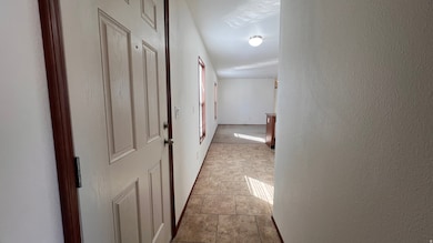Hall with light tile patterned floors and a textured wall