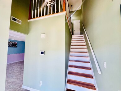 Stairway with a towering ceiling and tile patterned flooring