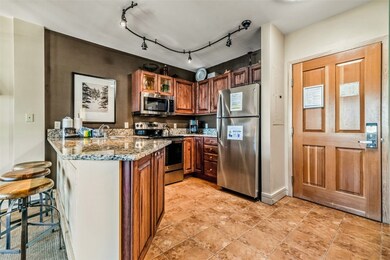 Kitchen with rail lighting, light tile patterned f