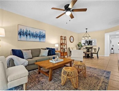 Living area featuring baseboards, light tile patte