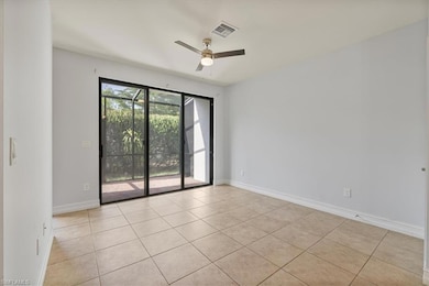 Unfurnished room featuring ceiling fan, light tile patterned floors, and baseboards