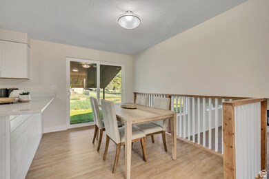 Dining room with light wood-type flooring and a textured ceiling