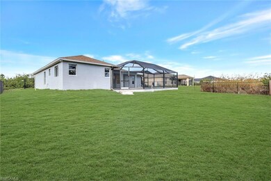 Back of house featuring a patio, a lawn, a lanai, 