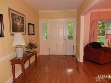 A large wood floored foyer with a great sight line