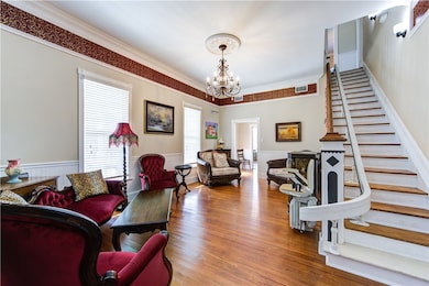 Living area with stairway, a chandelier, crown mol