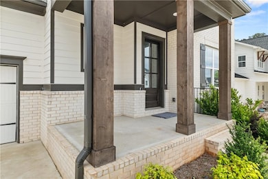 View of exterior entry featuring a porch and brick siding