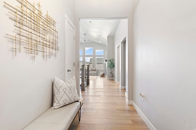 Hall featuring light wood-style flooring and lofted ceiling