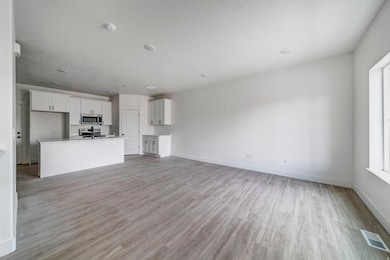 Unfurnished living room featuring light wood finished floors and a textured ceiling
