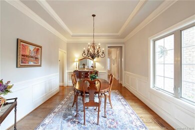Roomy formal dining room with tray ceiling and wai