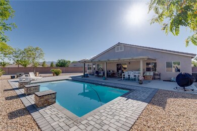 View of pool with an outdoor fire pit, a patio are