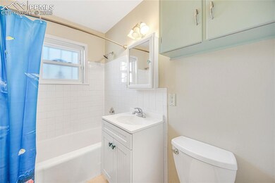 Full bathroom featuring toilet, shower / bath combo, and vanity