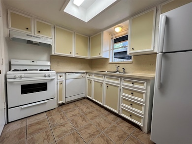 Kitchen with light countertops, white appliances, 