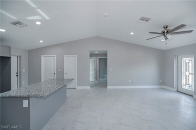 Kitchen with light stone countertops, ceiling fan,