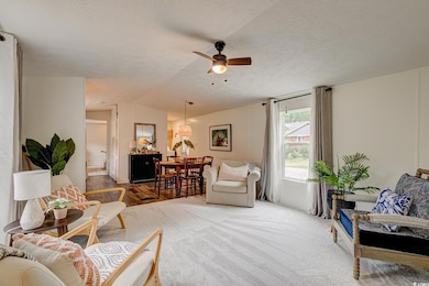 Living area featuring lofted ceiling, a ceiling fan, and a textured ceiling