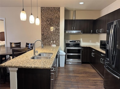 Kitchen with under cabinet range hood, a peninsula
