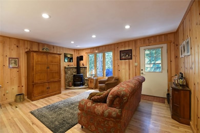 Living room featuring a wood stove, wood walls, he