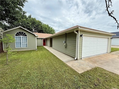 View of front of house with a front lawn and a gar