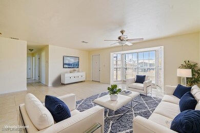 Living room with ceiling fan and light tile patter
