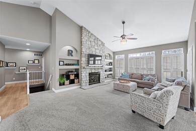 Stone fireplace is flanked by custom built in shel