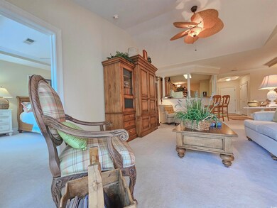 Living room with light colored carpet, vaulted ceiling, and ceiling fan