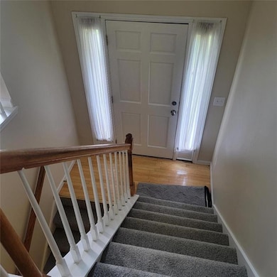 Staircase with wood finished floors and baseboards