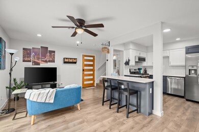 Living room with ceiling fan, light wood finished