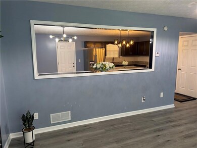 Living Room additional picture featuring a chandelier, wood finished floors, and a textured ceiling