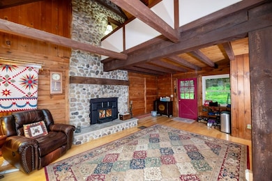 2-story stone fireplace with woodstove insert in l