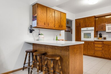 The spacious kitchen offers ample counter space and a peninsula with seating for three.