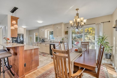 Dining room with light wood-style floors and a chandelier