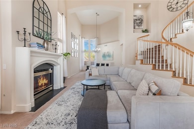 Carpeted living area with a high ceiling, stairway