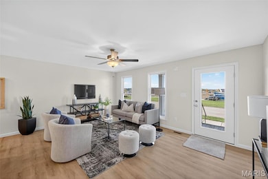 Living room featuring LVP flooring and ceiling fan
