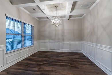Unfurnished room with coffered ceiling, a chandeli