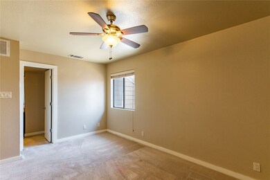 Empty room with light carpet, a textured ceiling, and ceiling fan