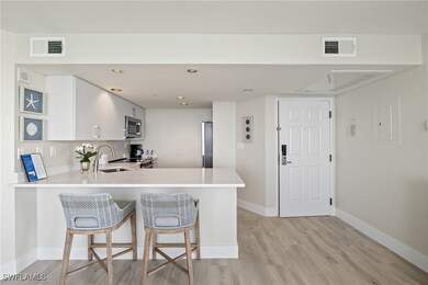 Kitchen featuring white cabinetry, sink, light har