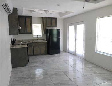 Kitchen with freestanding refrigerator, french doors, a tray ceiling, a sink, and stove