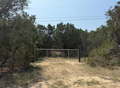 View of yard with a gate and a wooded view