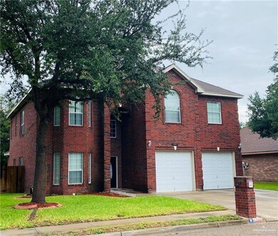 View of front of property with brick siding, a front yard, concrete driveway, and a garage