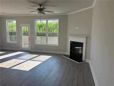 Unfurnished living room with dark wood-style flooring, ceiling fan, a fireplace with raised hearth, and crown molding