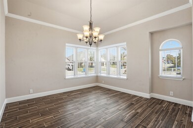 Unfurnished dining area with ornamental molding, wood tiled floors, and a chandelier