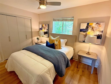 Bedroom with wood finished floors, a closet, a ce
