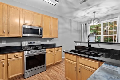 Kitchen with stainless steel appliances, a sink, l