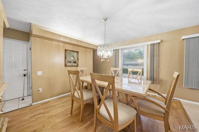 Dining area with light wood-style floors and a chandelier