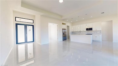 Kitchen featuring decorative backsplash, white cab