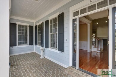 A lovely brick front porch has room for rocking ch