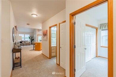 When you step inside, you'll find the guest bedroom to the right with the guest bath just off the main hallway. Looking ahead, you can see how open the floor plan is leading you to the kitchen, dining & great room